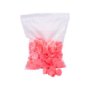 A bag of plain Pipe & Rebar Caps, with some of the caps in front of the bag (shown in Pink).